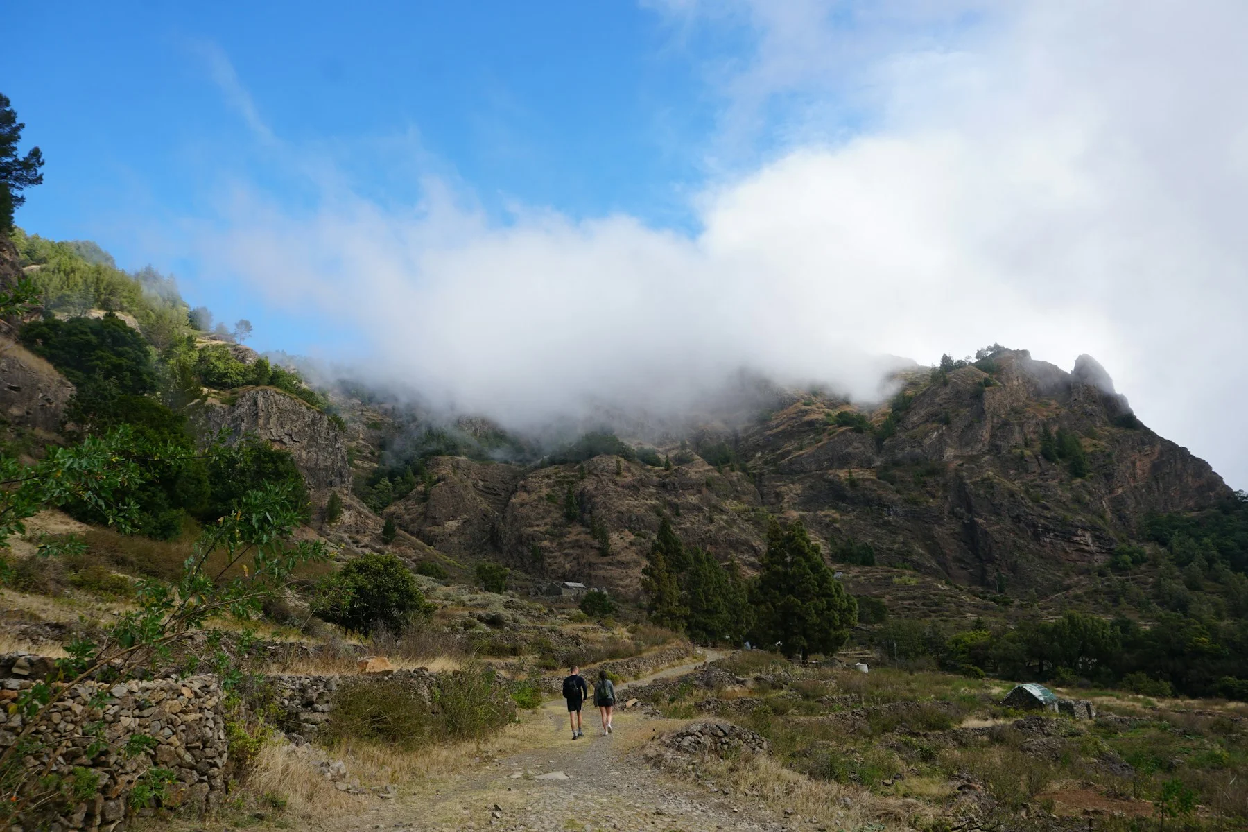 Marcheurs sur un chemin de montagne sous les nuages, sur Santo Antão.