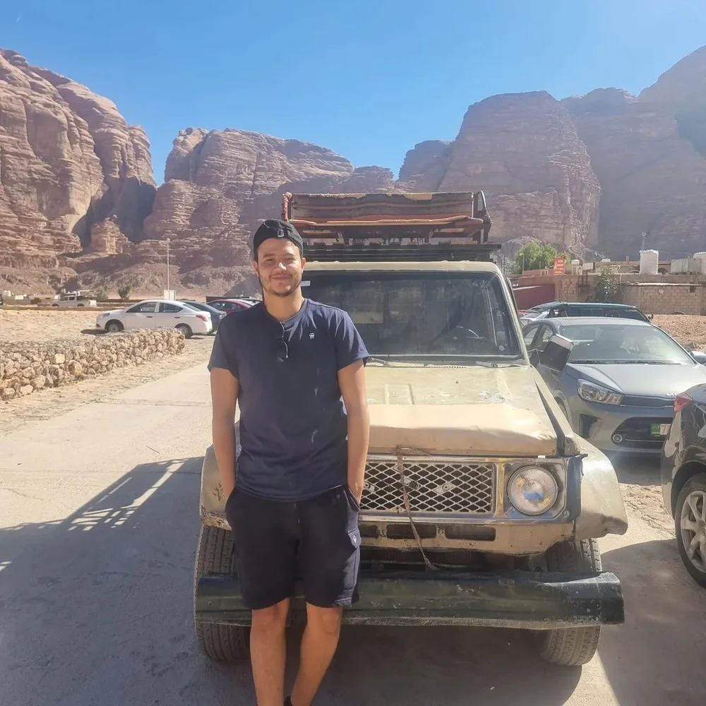Omar devant un véhicule dans un paysage rocheux